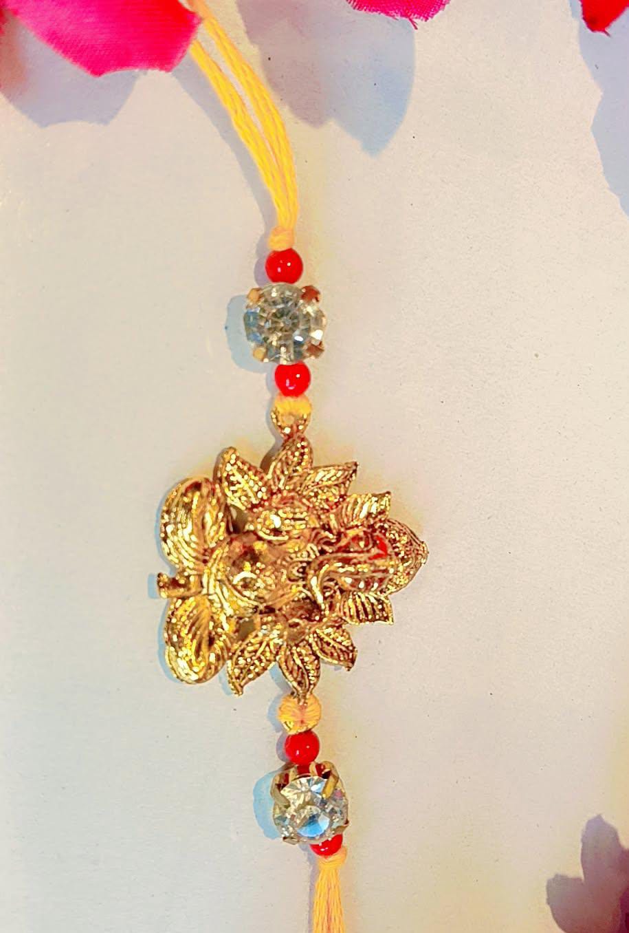 Handmade Ganesha Rakhi – Golden Finish with Red Beads & Crystal Stones (Single Piece)