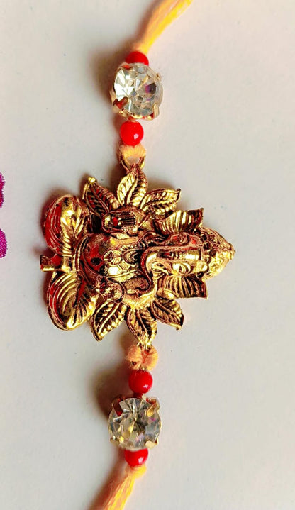 Handmade Ganesha Rakhi – Golden Finish with Red Beads & Crystal Stones (Single Piece)
