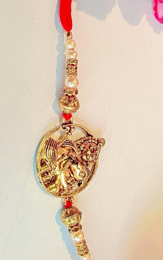 Handmade Bal Krishna Rakhi – Golden Charm with Pearl Beads & Red Thread (Single Piece)