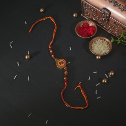 Handmade Rakhi – Traditional Orange Thread Rakhi with Circular Beaded Centerpiece