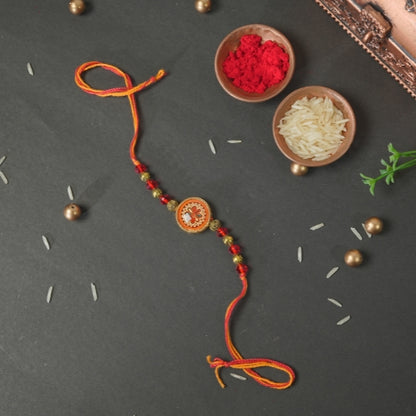 Handmade Rakhi – Traditional Orange Thread Rakhi with Circular Beaded Centerpiece