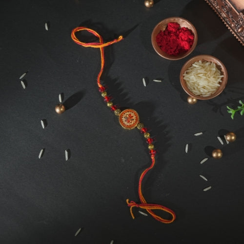 Handmade Rakhi – Traditional Orange Thread Rakhi with Circular Beaded Centerpiece