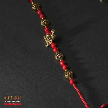 Antique Krishna Rakhi with Brass Murli Motif and Red Beaded Thread – Handmade Rakhi for Brother