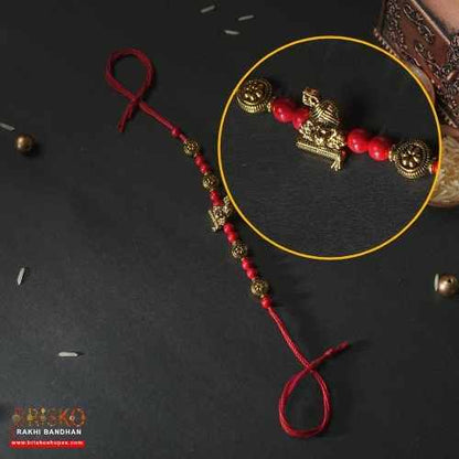 Antique Krishna Rakhi with Brass Murli Motif and Red Beaded Thread – Handmade Rakhi for Brother